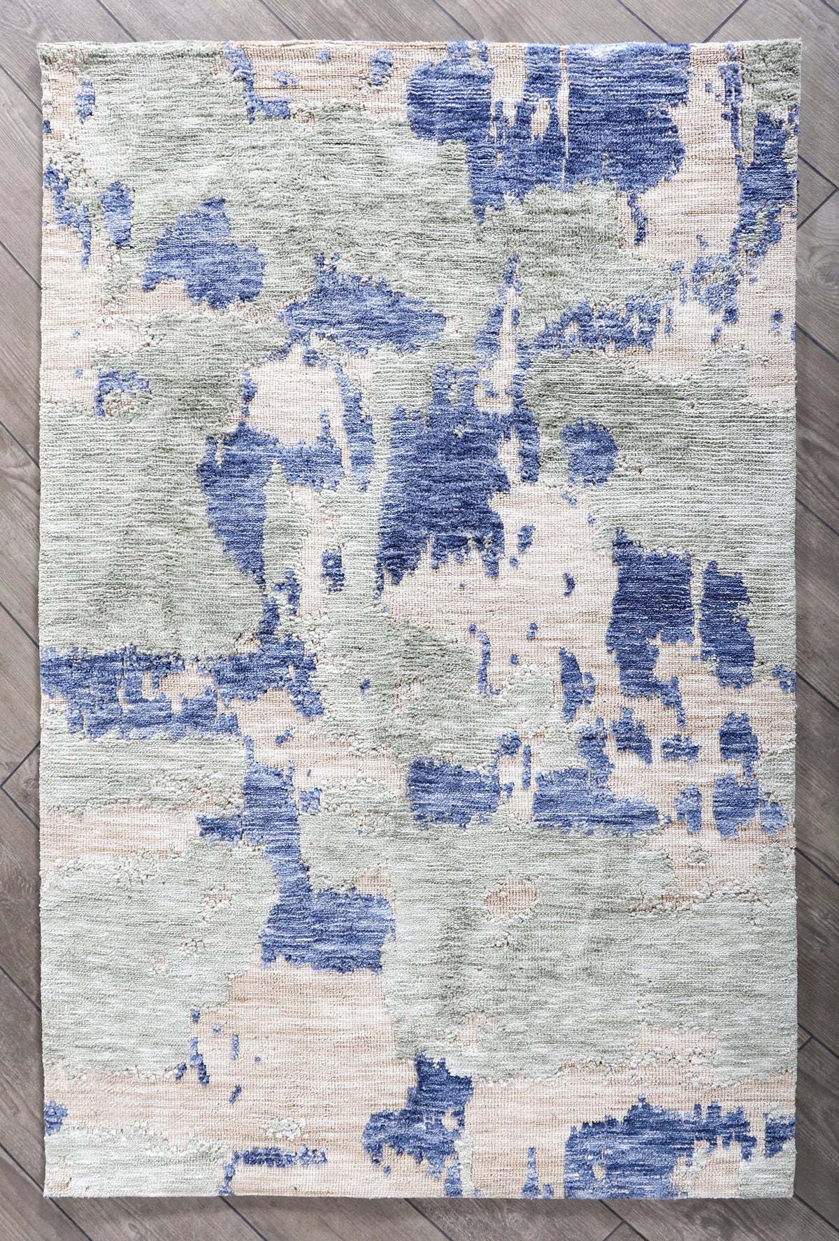Premium high low weave rug handcrafted in India with circular knitting, showcasing denim, olive, grey, and natural tones.